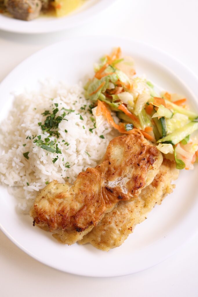 Service-2-min Tasty chicken fillet with steamed rice and fresh salad on a white plate.
